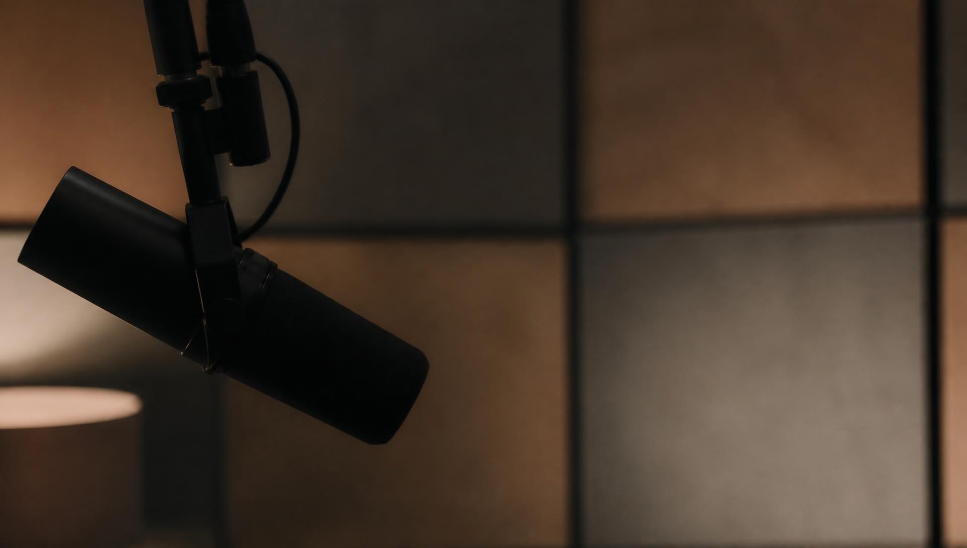 A broadcast microphone in a softly lit studio